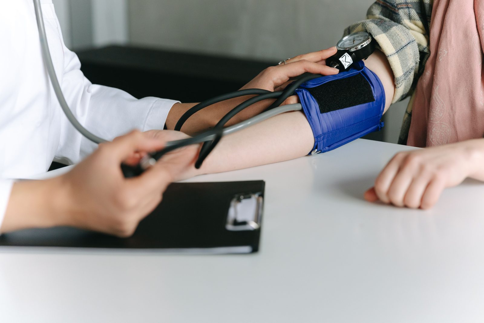 A clinician taking a patient's blood pressure with a cuff