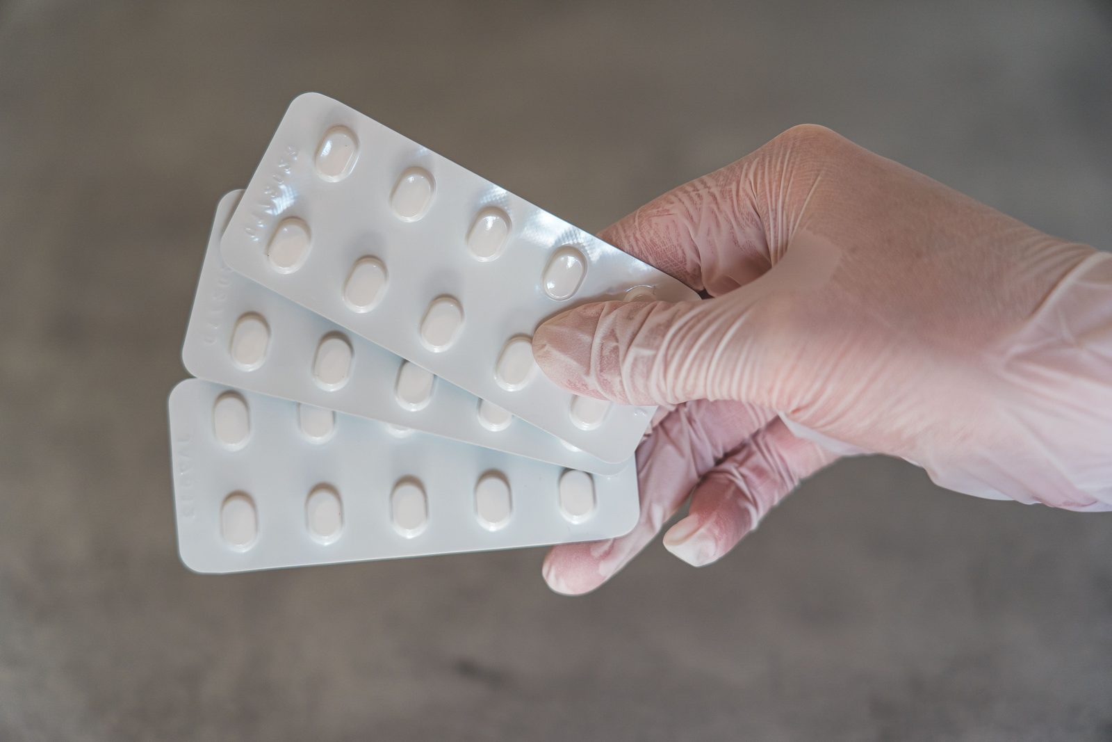 A hand holding a blister pack of tablets