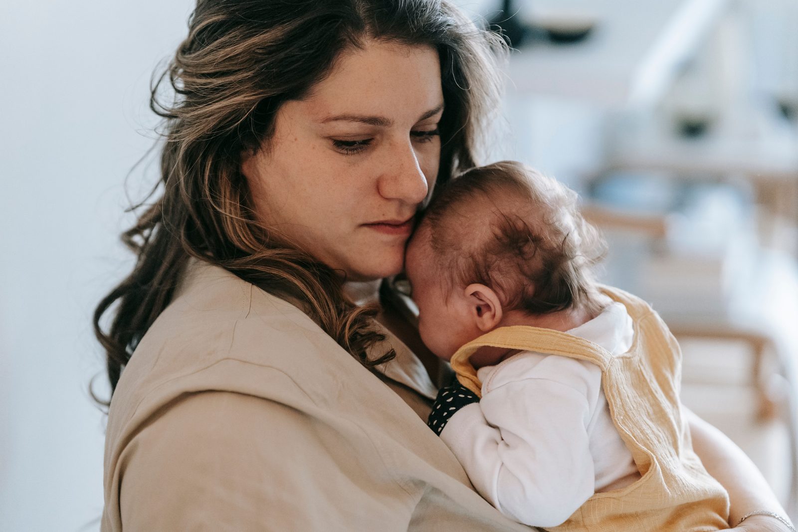 A mother holding her newborn close at home