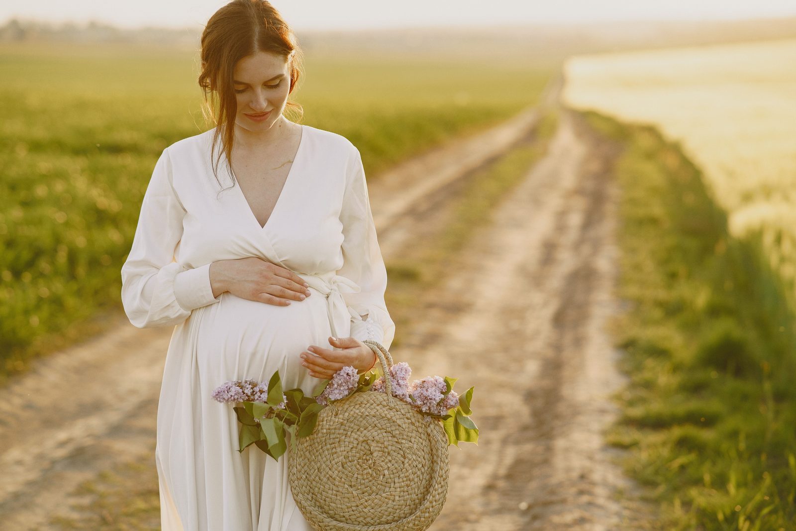 A pregnant woman walking along a rural dirt road