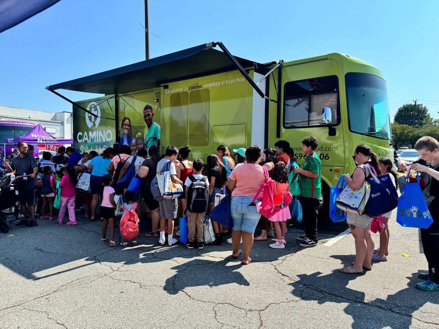 Families lining up at a Camino Salud mobile health clinic community event